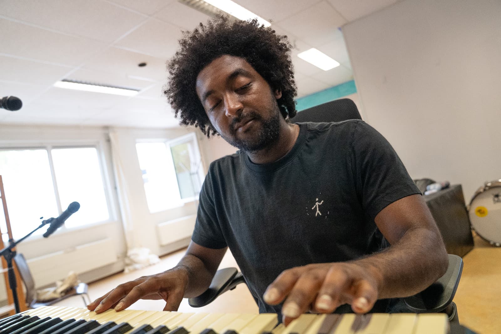 Jarrel speelt keyboard in de studio waar het muziektraject plaatsvindt